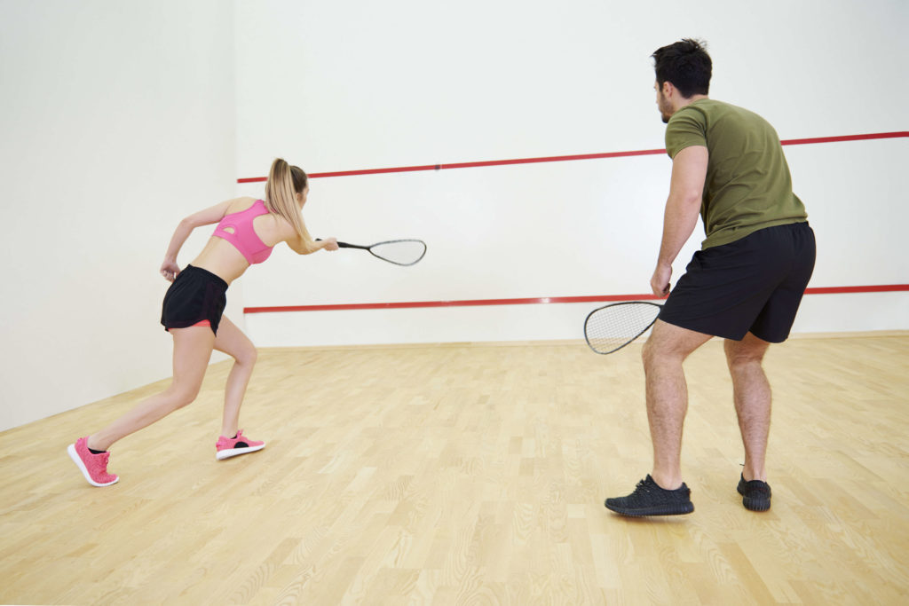 Man and woman playing squash
